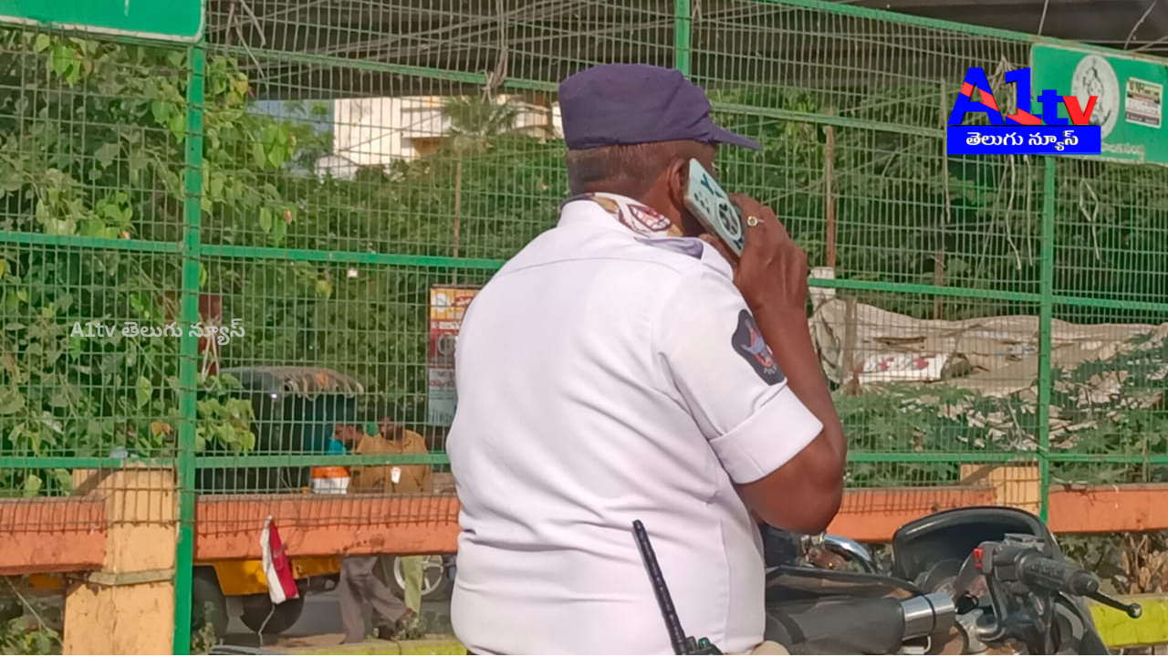 Rules for public, exemptions for officials? Traffic constable caught riding without a helmet while talking on the phone.