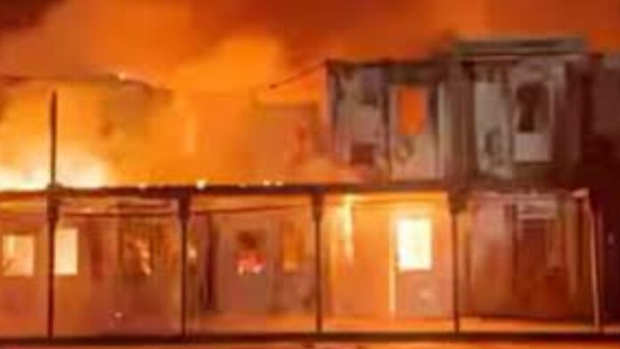 Damaged hospital in Kabul after Pakistan airstrike, smoke rising, rescue teams at work.